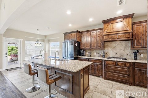 A kitchen with wooden cabinets and a granite countertop.