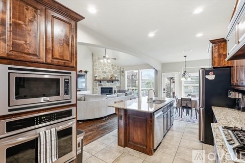 A modern kitchen with dark wood cabinets and stainless steel appliances.
