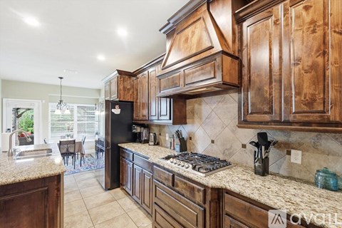 A kitchen with wooden cabinets and a granite countertop.