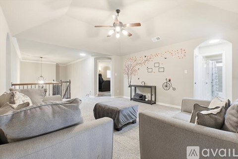 A living room with a grey couch and a fireplace.