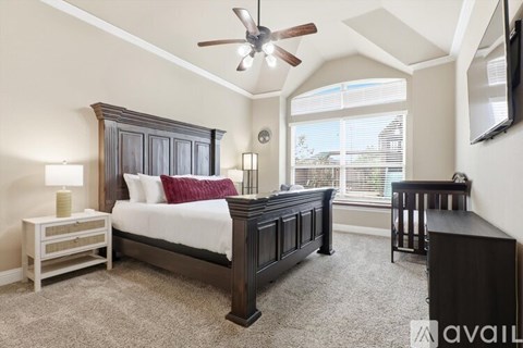 A bedroom with a large bed and a ceiling fan.
