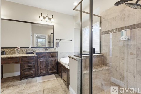 A bathroom with a marble countertop and a walk-in shower.