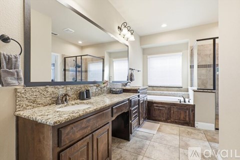 A bathroom with a marble countertop and a large mirror.