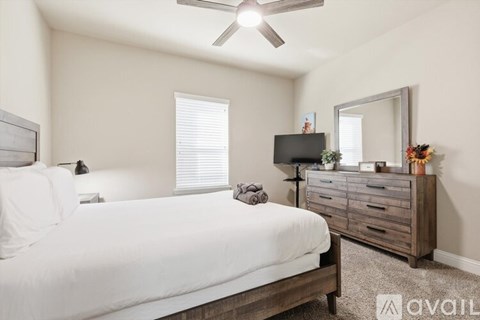 A bedroom with a bed, dresser, and mirror.