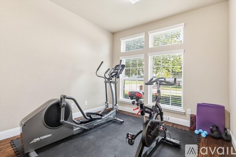 A room with a treadmill and exercise bike.