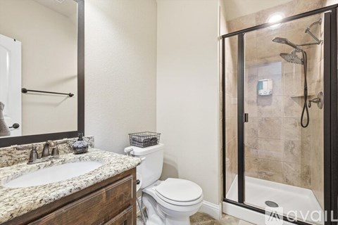 A bathroom with a toilet, sink, and shower.
