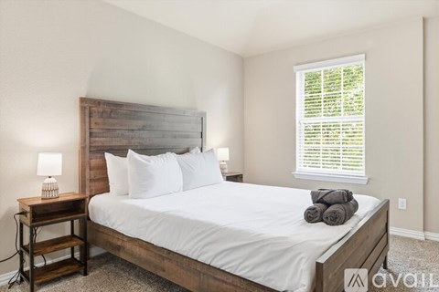 A bedroom with a large bed and a wooden headboard.
