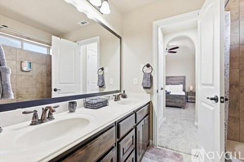 A bathroom with a large mirror above a double sink vanity.