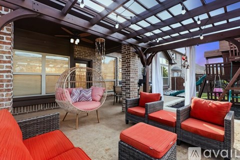 A patio with red cushions and a woven chair.