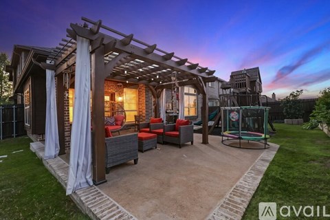 A backyard with a pergola and a swing set.