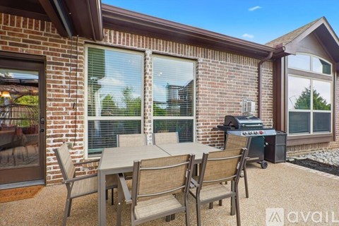 A patio with a table and chairs is set up outside a house.