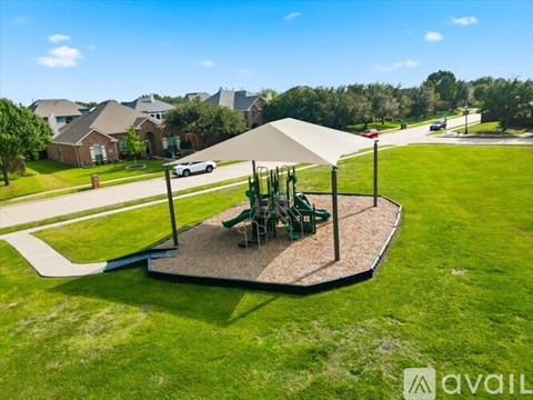 A playground with a slide and a swing set in a grassy area.