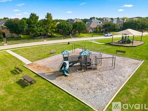A playground with a green swing set and a blue slide.
