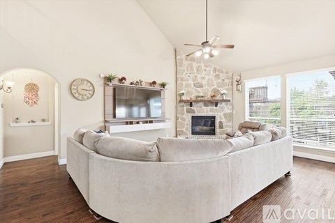 A living room with a large couch and a fireplace.
