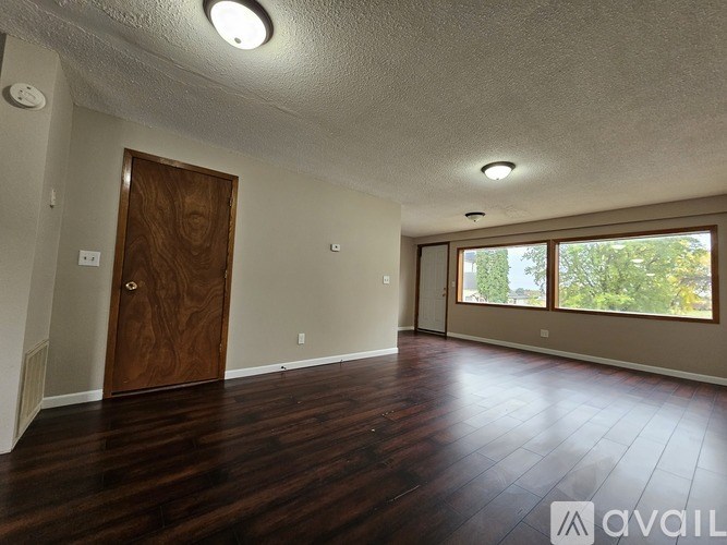 A room with a wooden door and a window with blinds.