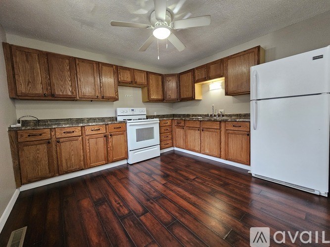 A kitchen with wooden cabinets and a white refrigerator.