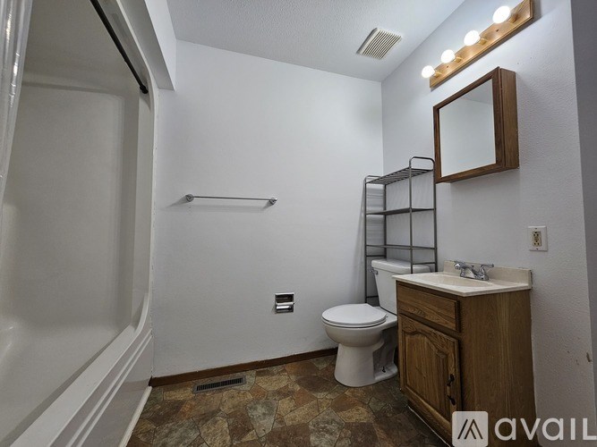 A bathroom with a toilet, sink, and a mirror.