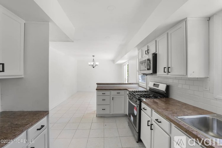 A kitchen with white cabinets and a brown countertop.