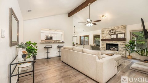 A living room with a white couch and a fireplace.