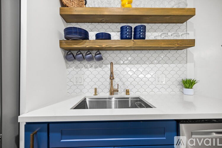 A kitchen with a white countertop and blue cabinets.