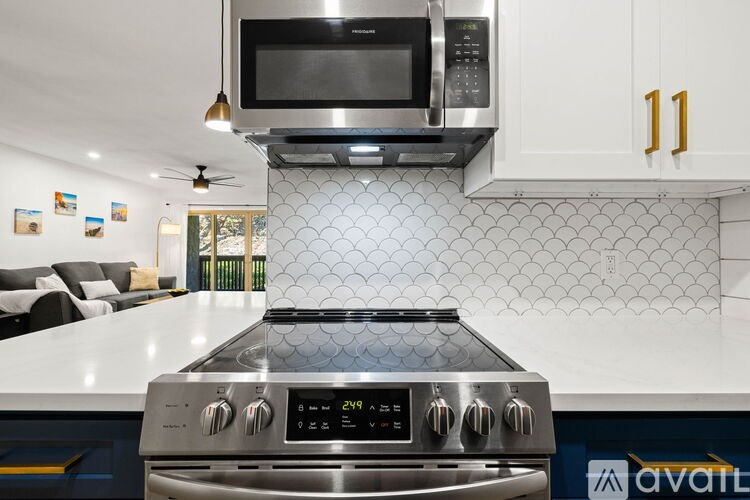 A modern kitchen with a stove top oven and microwave above it.