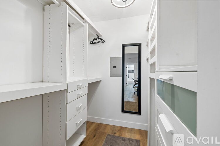 A hallway with a mirror and a coat rack.