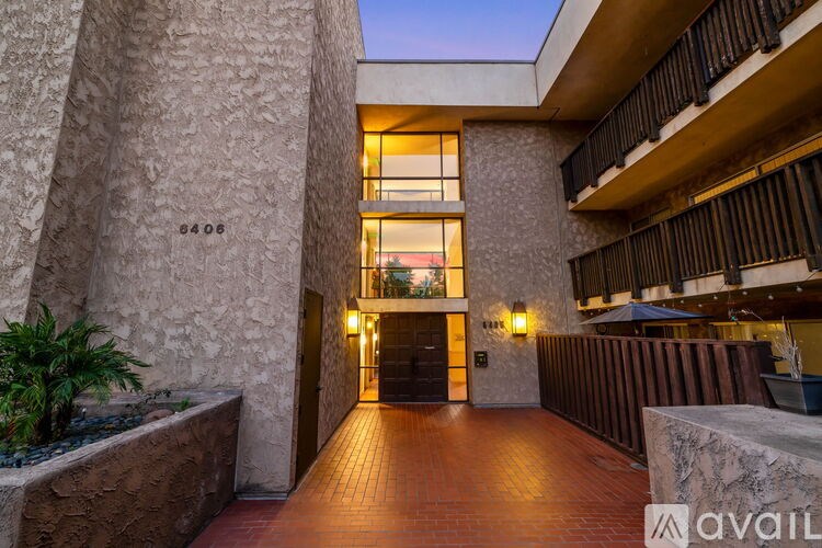 A building entrance with a stone wall and a wooden floor.