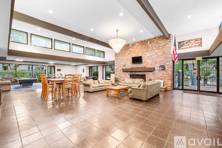 A large open living room with a fireplace and a dining table.