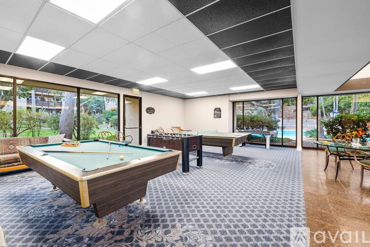 A room with a pool table and a dining table.