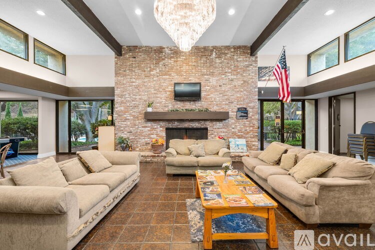 A living room with a stone fireplace and a large sectional sofa.