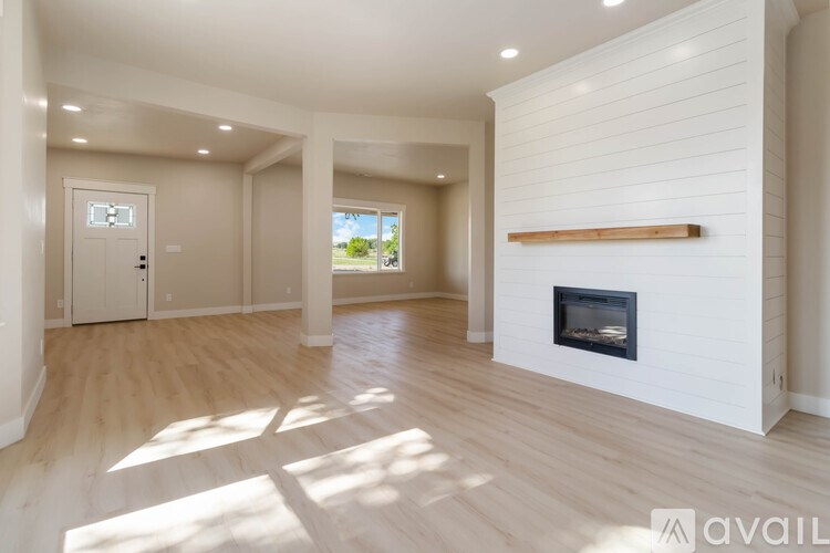 A spacious living room with a fireplace and wooden floors.