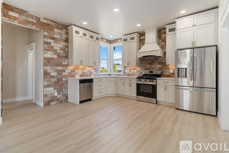A kitchen with white cabinets and a brick wall.