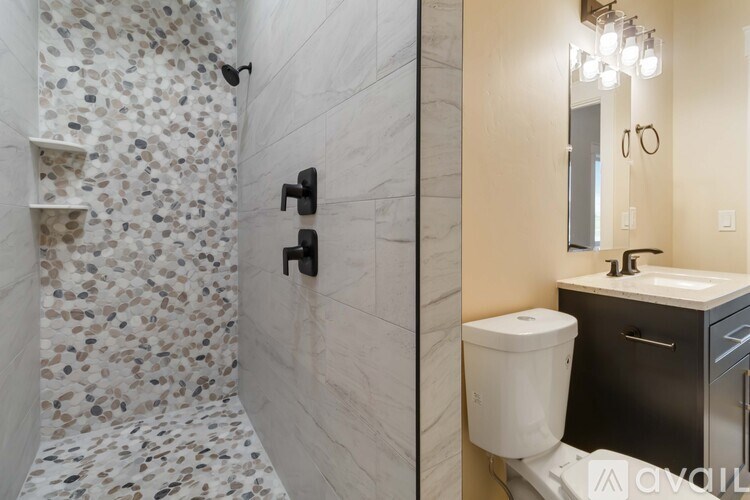 A bathroom with a walk-in shower and a sink.