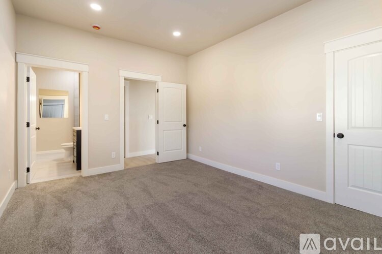 A spacious room with a carpeted floor and white walls.