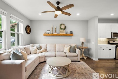 A living room with a white couch and a ceiling fan.