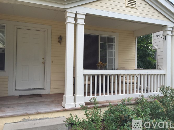 A white door is on the left side of a porch.