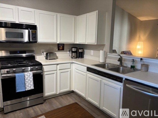 A kitchen with white cabinets and a black stove top.
