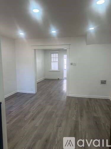 A room with wooden flooring and a window.