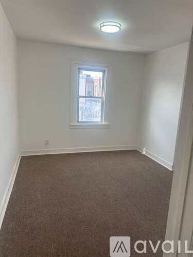 A room with a carpeted floor and a window.