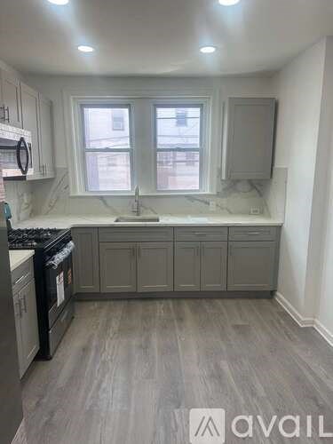 A kitchen with a black stove top oven and a sink with a faucet.