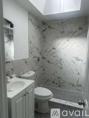 A bathroom with marble wallpaper and a toilet.