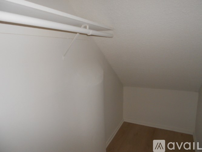 A small room with a white ceiling and a wooden floor.