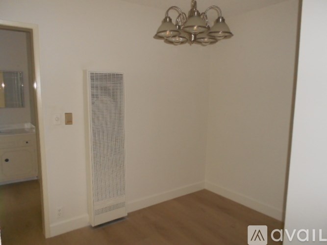 A room with a white wall and a chandelier.