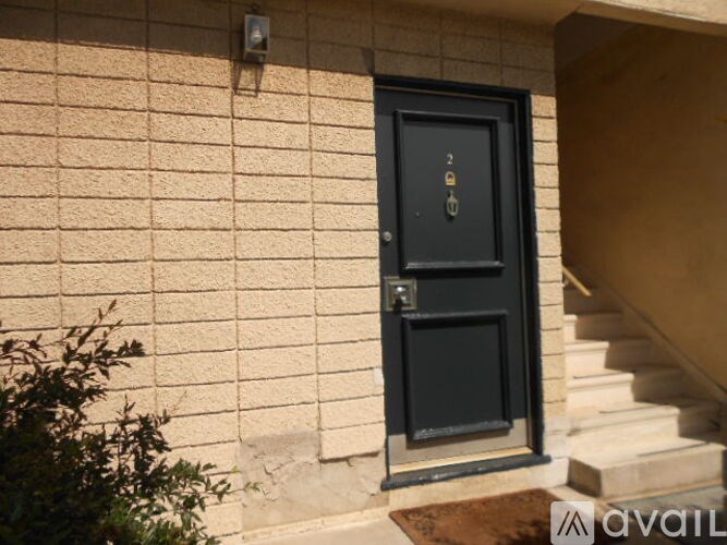 A black door with a glass window is on a beige wall.