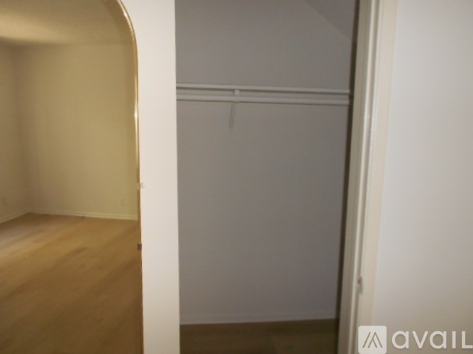 A room with a white wall and a wooden floor.