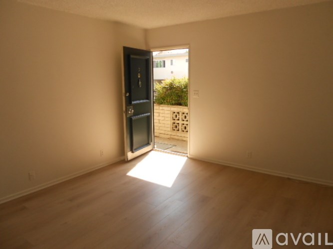 A room with a black door and wooden floor.