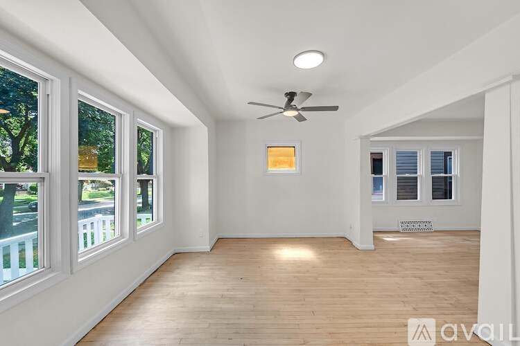 A room with a ceiling fan and wooden flooring.