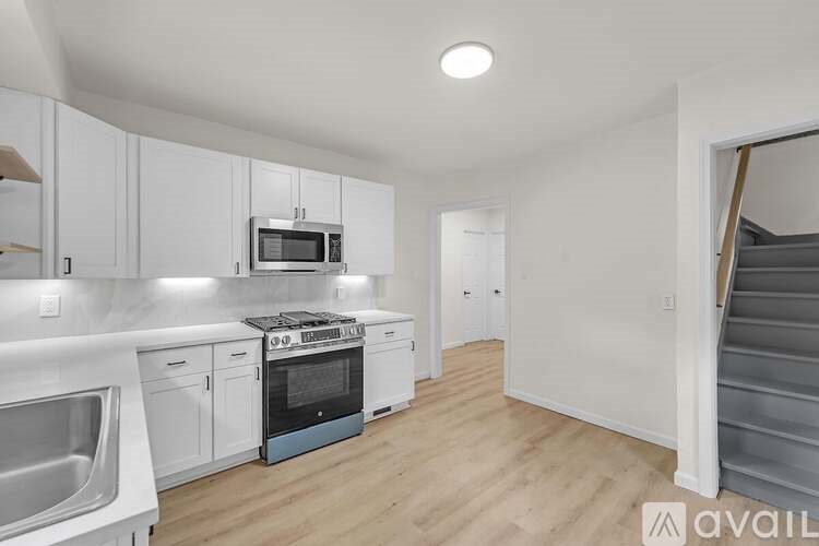 A kitchen with white cabinets and a blue oven.
