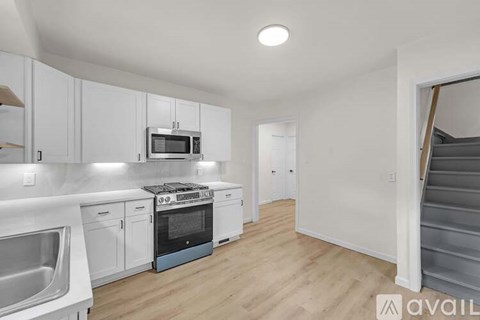 A kitchen with white cabinets and a blue oven.