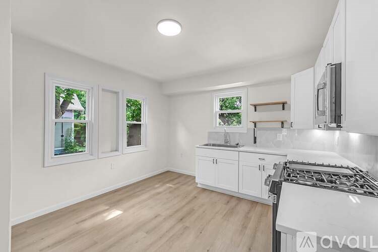 A kitchen with white cabinets and a stove top oven.